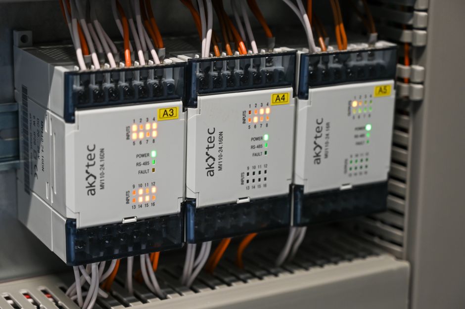 Close-up of industrial control boxes with wires and lights.