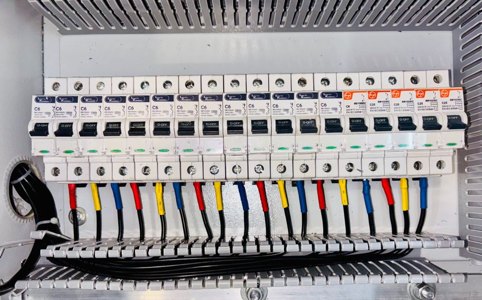 Close-up of an organized circuit breaker panel featuring color-coded electrical wiring.